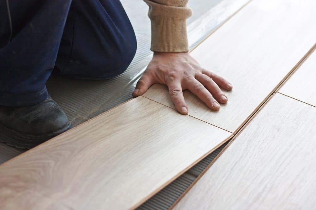 worker makes markup laying laminate flooring
